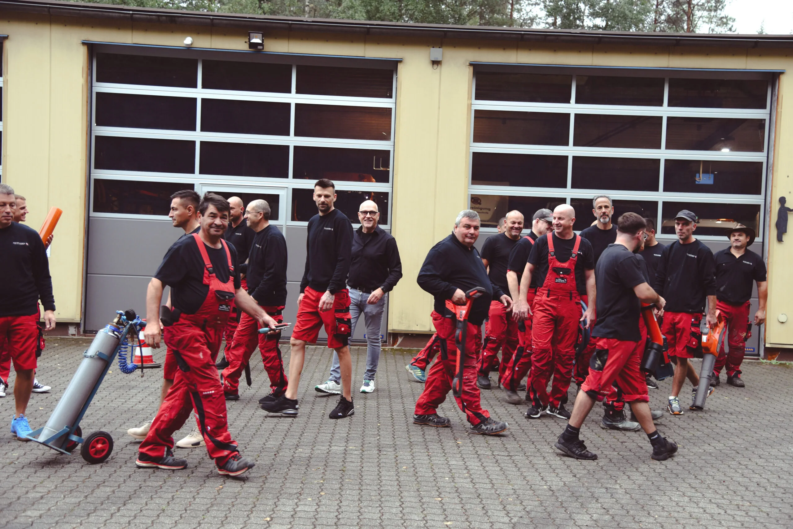 Team der Baier Rohrreinigung mit Spülgeräten vor der Fahrzeughalle