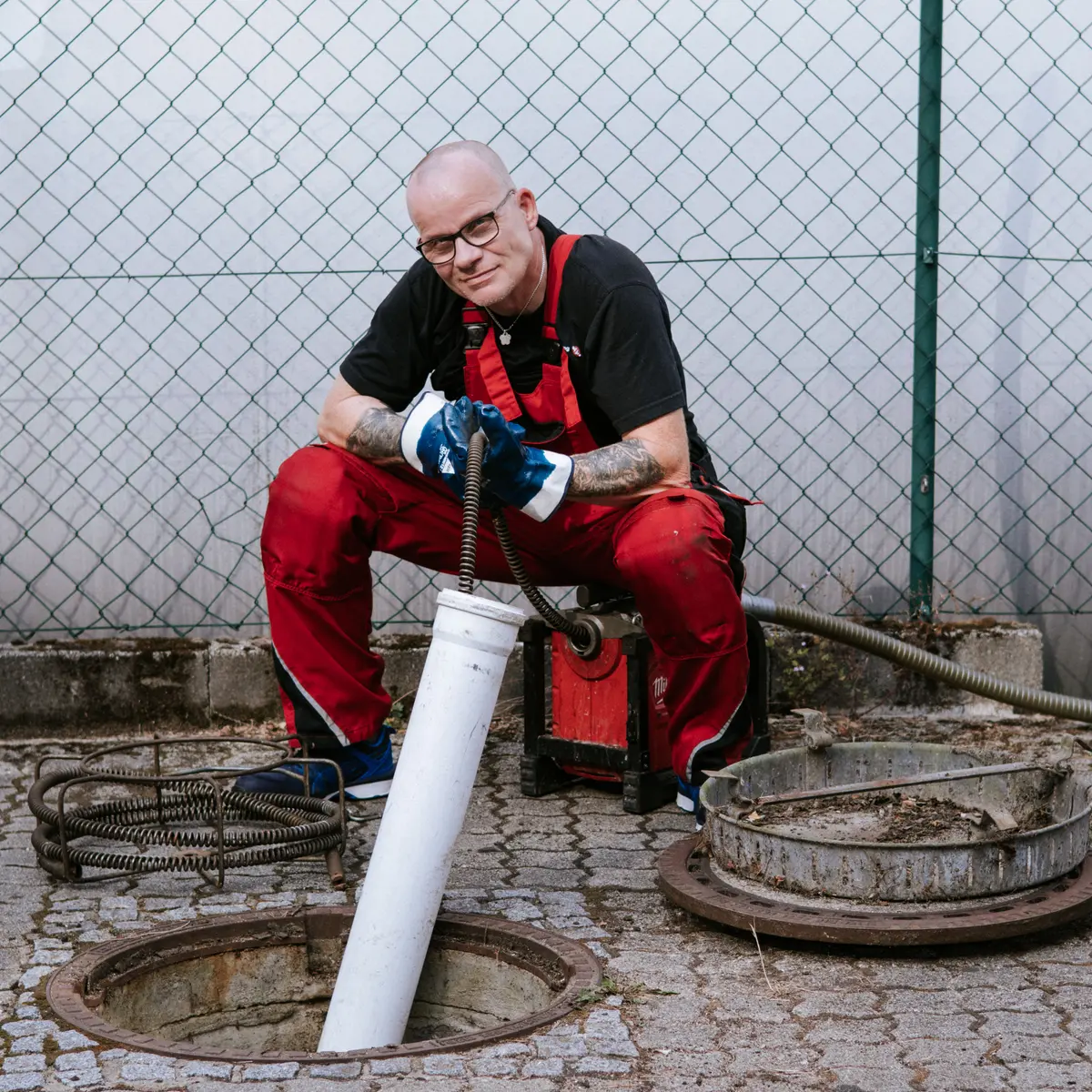 Techniker der Baier Rohrreinigung am geöffneten Kanalschacht