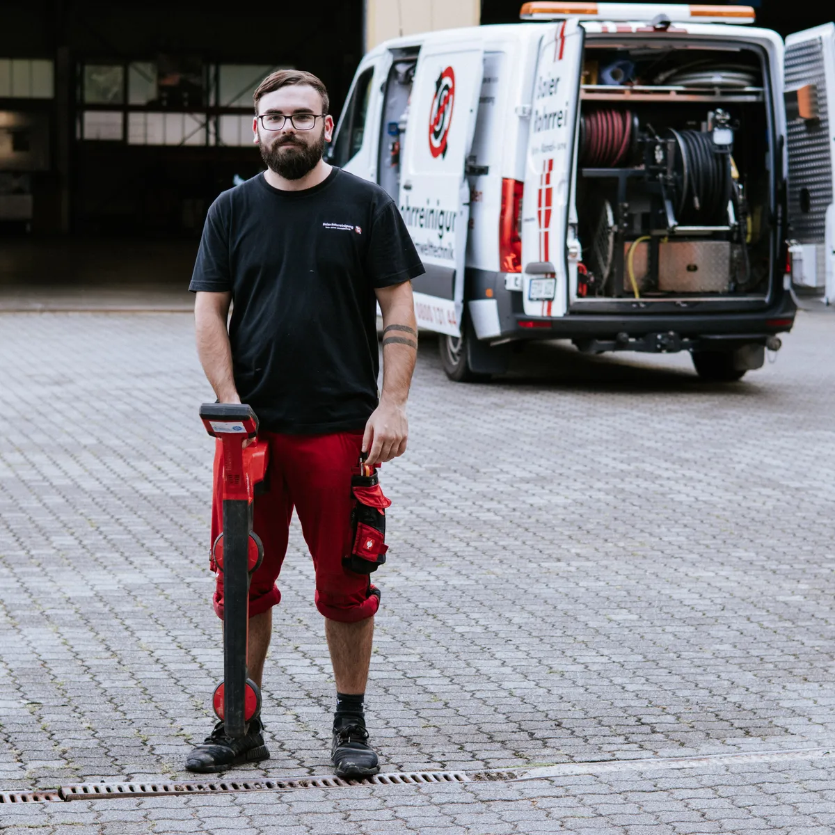 Techniker der Baier Rohrreinigung mit dem Ortungsgerät vor dem Einsatzfahrzeug