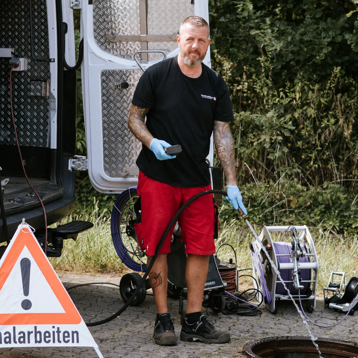 Techniker der Baier Rohrreinigung bei Spülarbeiten am offenen Schacht